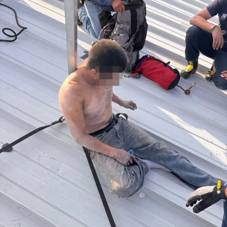 Un hombre en grave riesgo en las  alturas de una tienda, rescatado